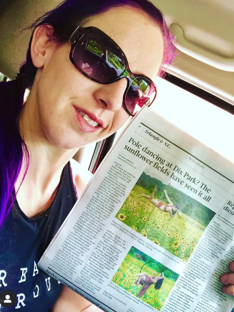 Dakota Fox holding a newspaper feature about her work