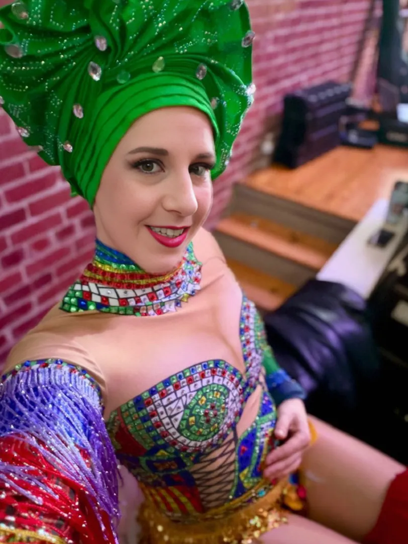 Dakota Fox in a green sequined headpiece and rhinestone costume