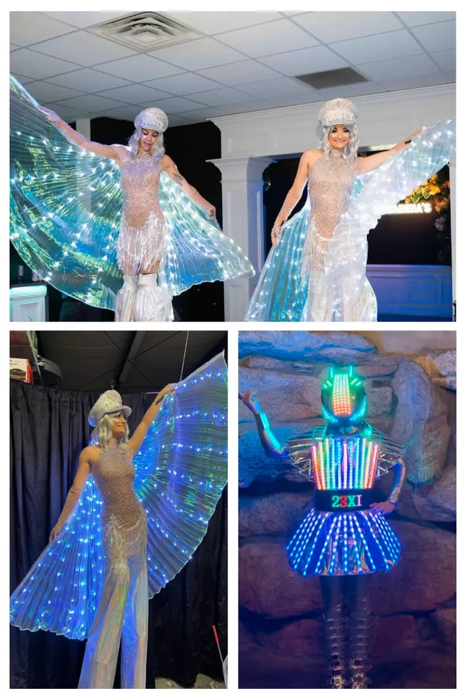 Performers in LED light up wings and an illuminated costume