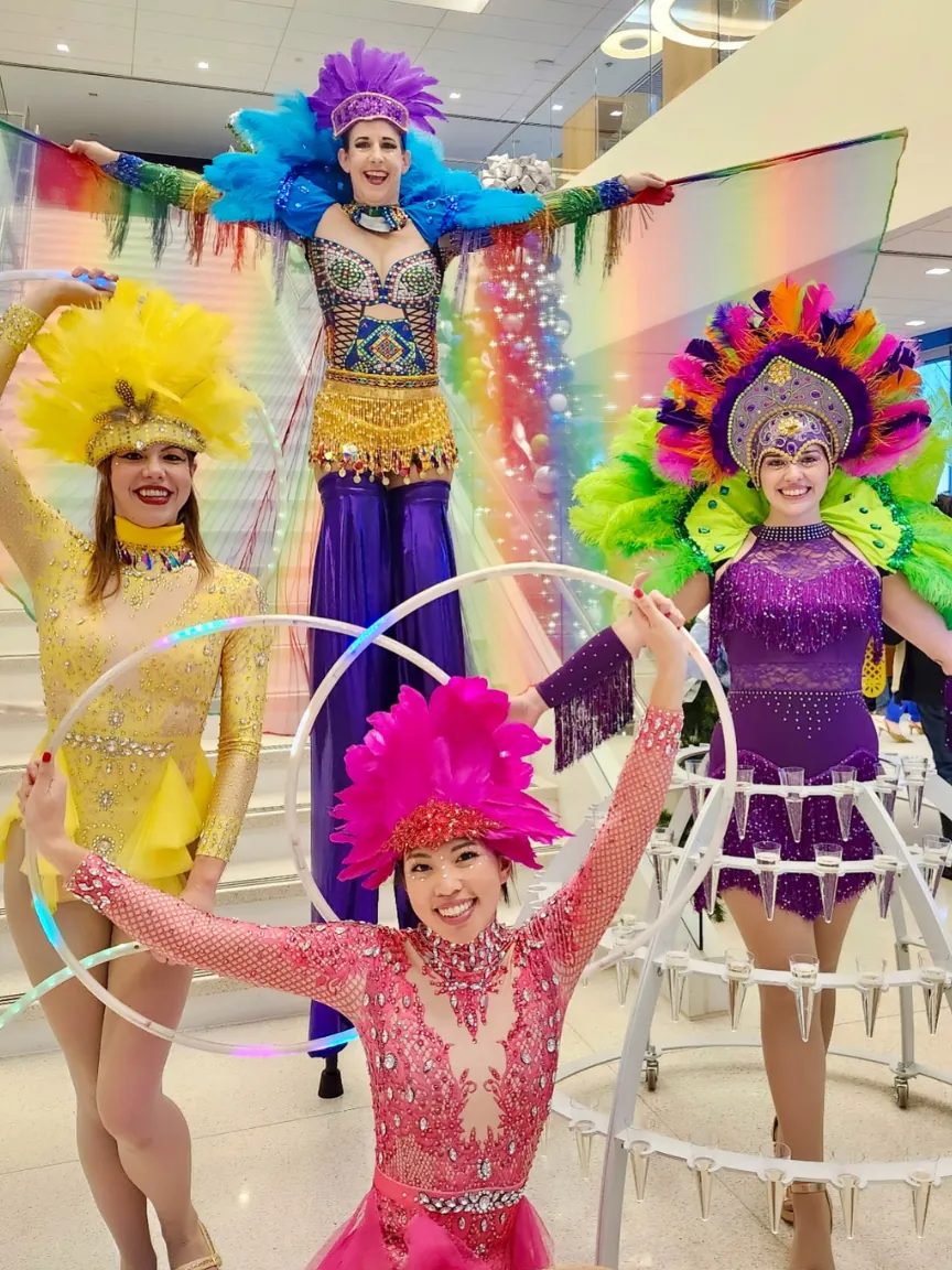Carnival stilt walkers with feather headdresses and hula hoops